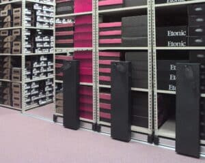 Industrial metal shelving system with multiple shelves holding boxes and items in a storage space.