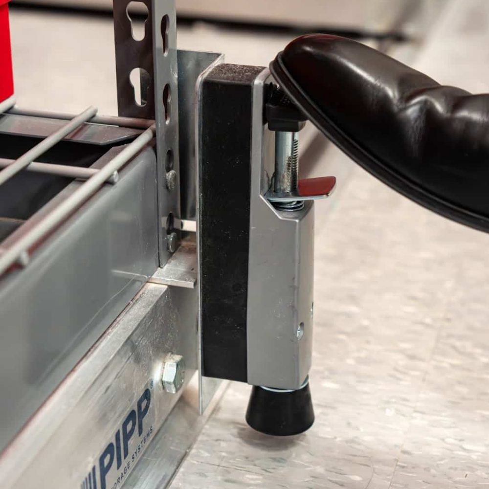 somone stepping on the break of a mobile shelving storage unit